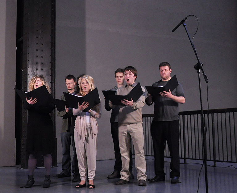 A group of singers holding hymn sheet